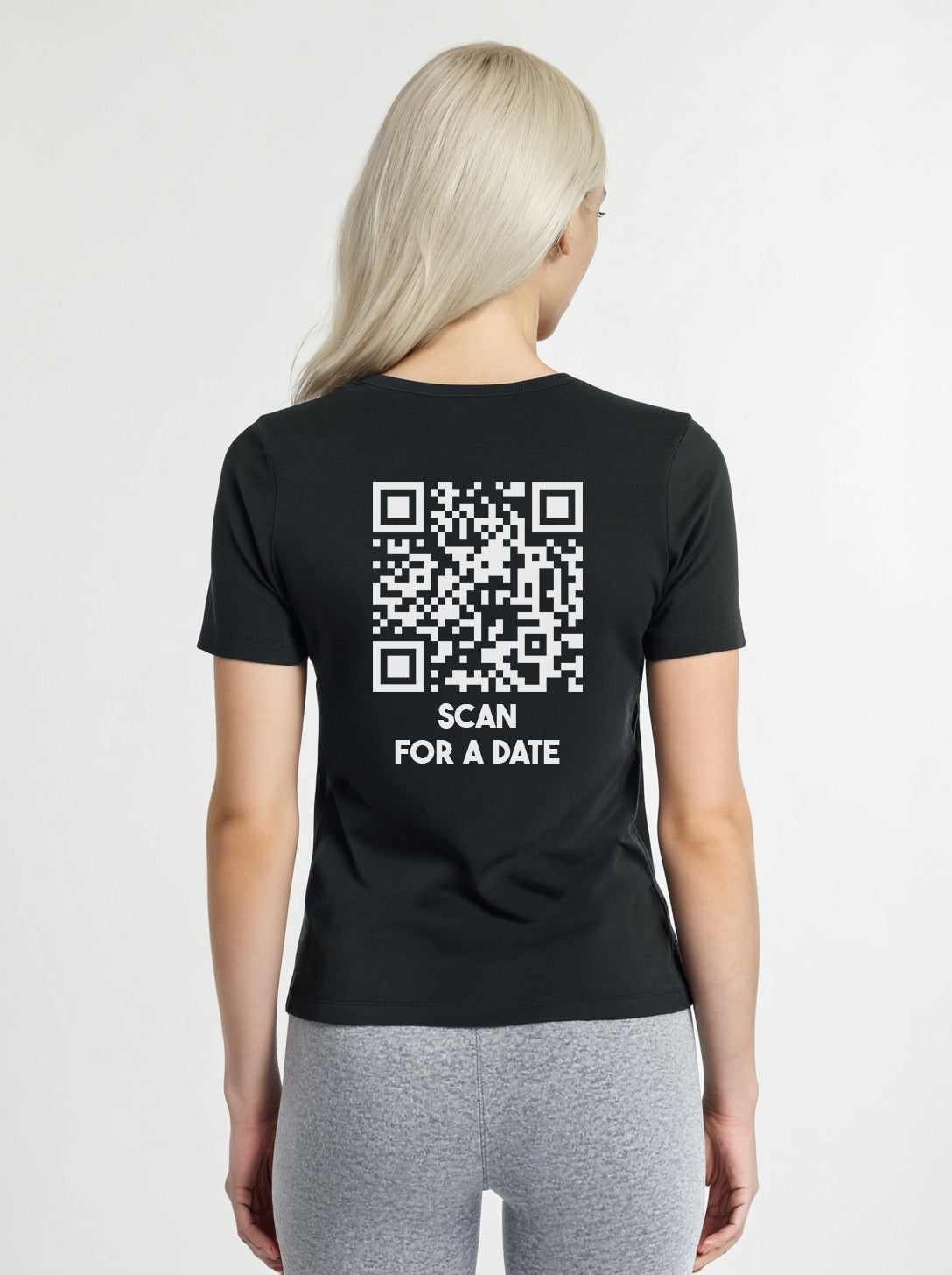 Woman wearing a black t-shirt from Cue R with a white QR code and 'SCAN FOR A DATE' text on the back.