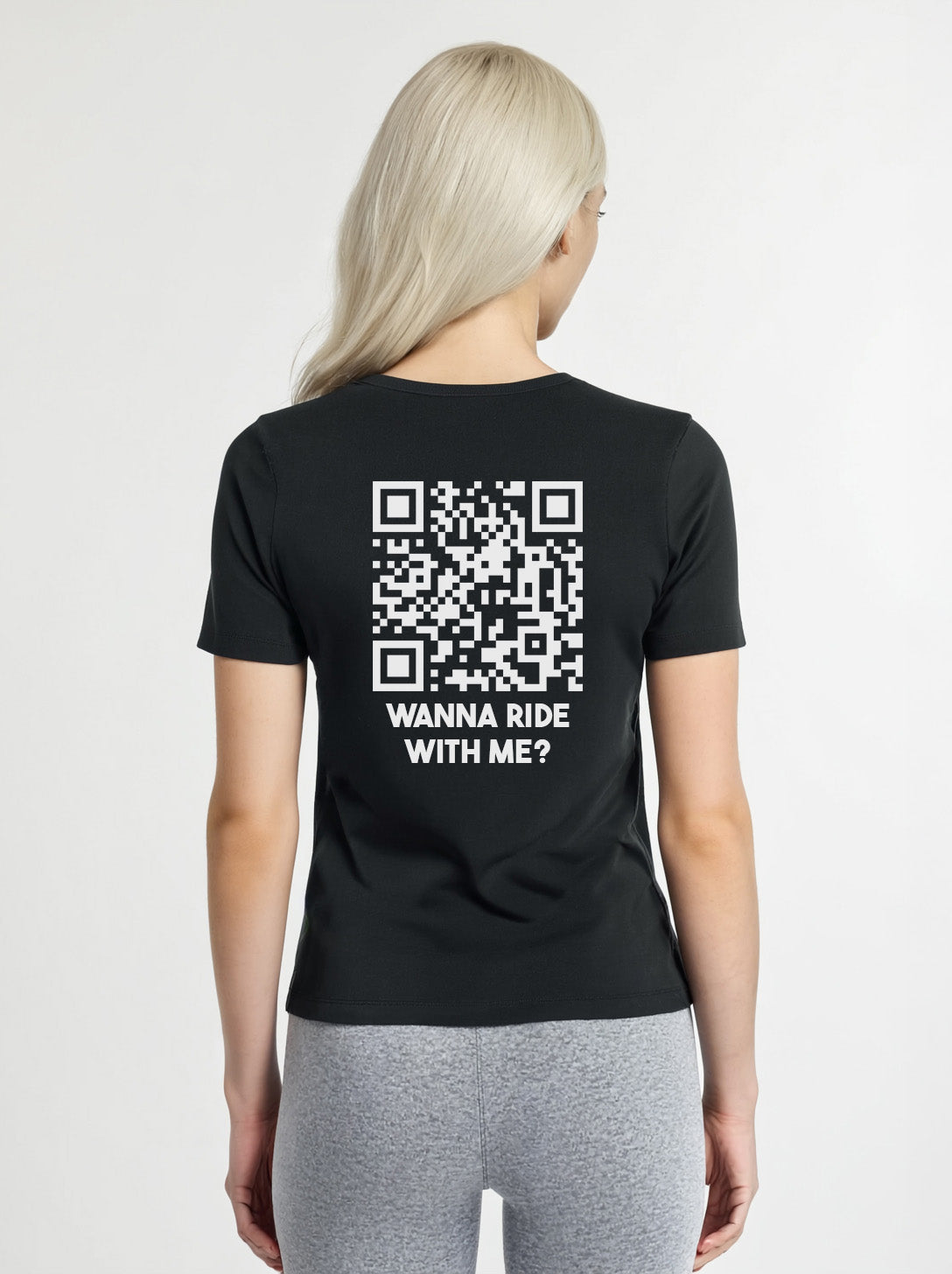Woman wearing a black t-shirt from Cue R with a white QR code and 'WANNA RIDE WITH ME?' text on the back.