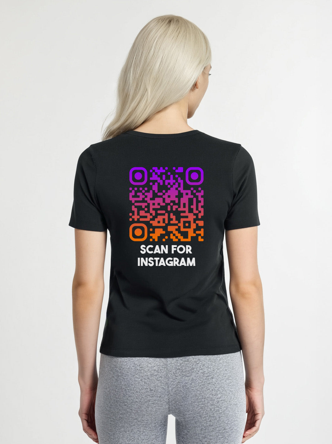 Woman wearing a black t-shirt from Cue R with a purple-orange QR code and 'SCAN FOR INSTAGRAM' text on the back.