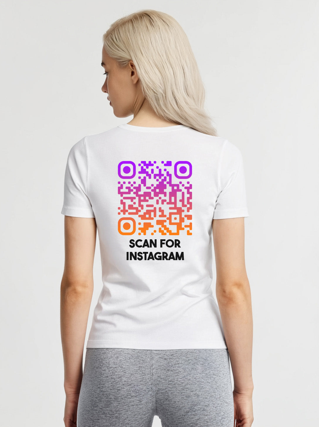 Woman wearing a white t-shirt from Cue R with a purple-orange QR code and 'SCAN FOR INSTAGRAM' text on the back.
