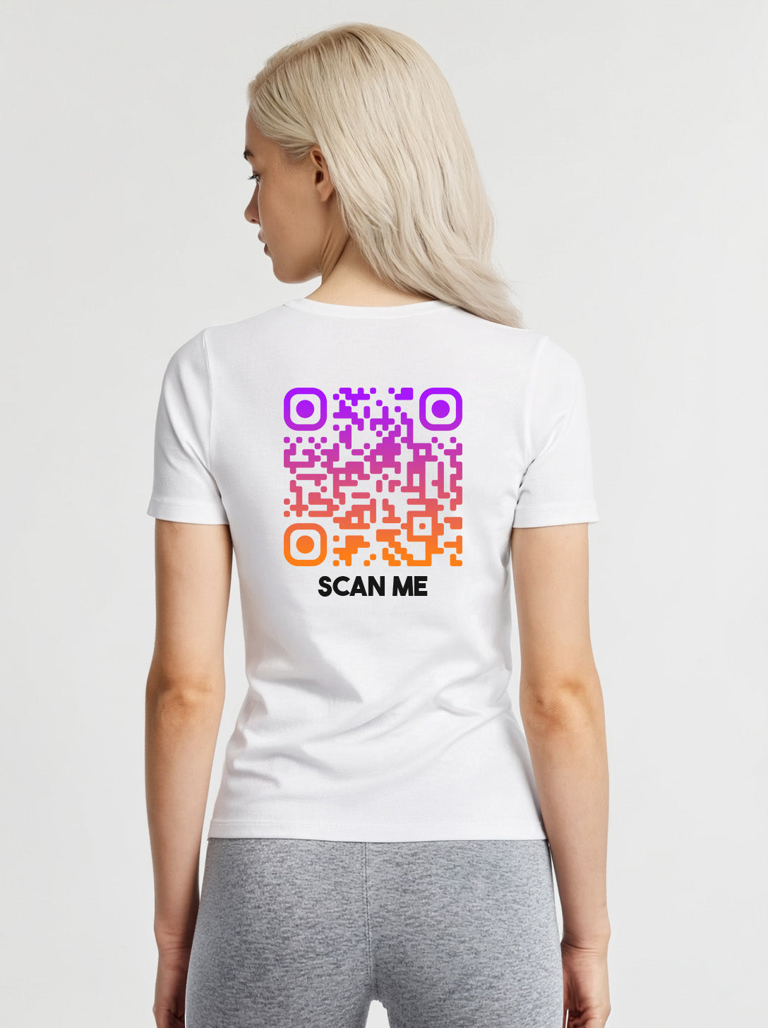Women wearing a white t-shirt from Cue R with a purple-orange QR code and 'SCAN ME' text on the back.